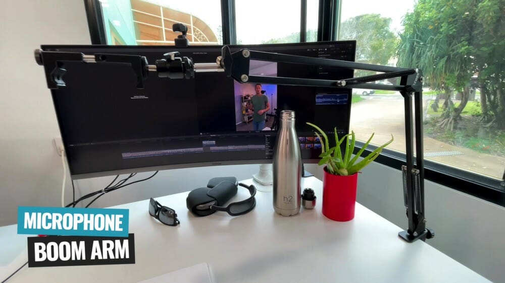 A microphone boom arm attached to Justin's desk